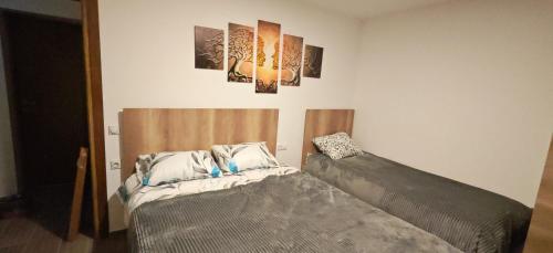 een slaapkamer met 2 bedden en 2 schilderijen aan de muur bij Suncani Breg in Crni Vrh