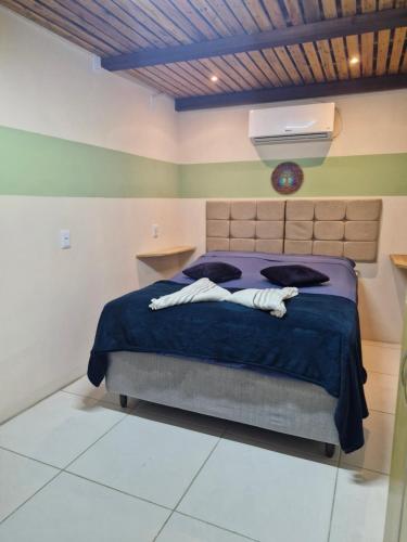 a bedroom with a bed with a blue comforter at Solar de Bonito - Casa Ingá in Bonito