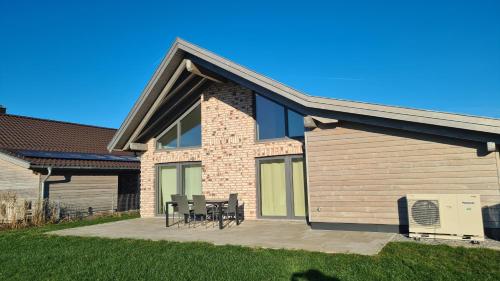 een huis met een patio met tafels en stoelen bij Haus Lüchtje Jade in Sehestedt