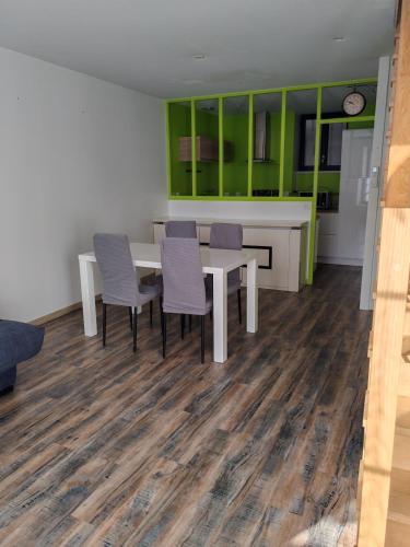 ein Esszimmer mit einem Tisch, Stühlen und grünen Schränken in der Unterkunft Arçais in Arçais