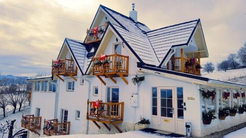a white house with balconies in the snow at Carpathia Magic -adults only in Peştera