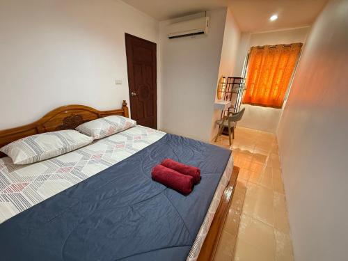 een slaapkamer met een bed met een rood kussen erop bij Bophut residence & House in Bophut 