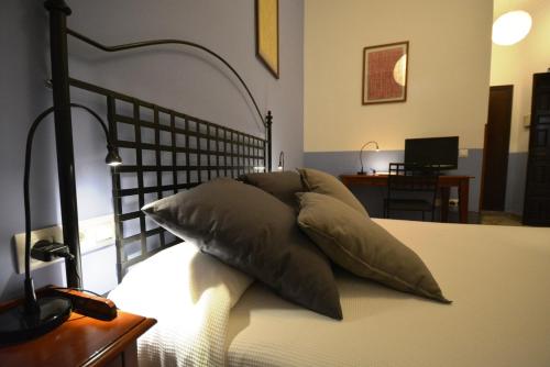 a bed with four pillows on top of it at Hotel Casa de los Azulejos in Córdoba