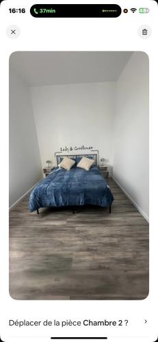 una camera da letto con un letto con una coperta blu di La maison du bonheur a Montluçon