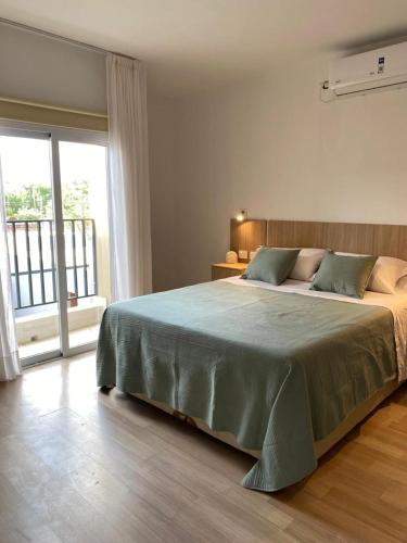 a bedroom with a large bed and a large window at Aires del Rio Apart in Villa de Soto