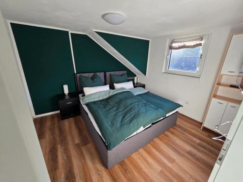 ein Schlafzimmer mit einem Bett und einer grünen Wand in der Unterkunft GreenHell Stays in Adenau