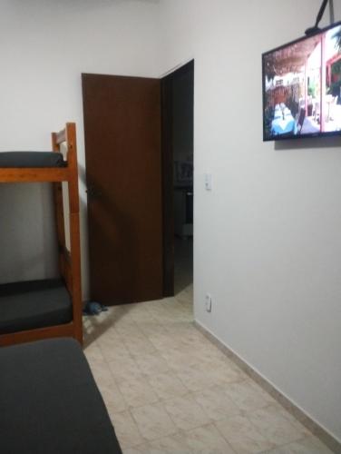 Cette chambre dispose d'une porte et d'une télévision murale. dans l'établissement Kitnet Cabo Frio 10, à Cabo Frio