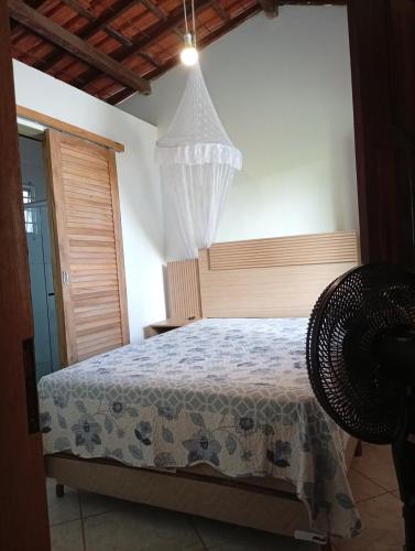 a bedroom with a bed and a chandelier at Casa Beija Flor in Itacaré