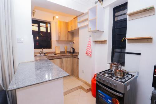 a kitchen with a stove and a counter top at Modern 1BR Apartment in Membley & near Ruiru Bypass, Kenyatta University & AMREF, Fast WiFi & Parking-Ruiru Membley in Ruiru