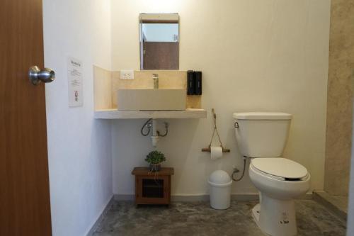 a bathroom with a white toilet and a sink at Casa Calandria in Chicxulub