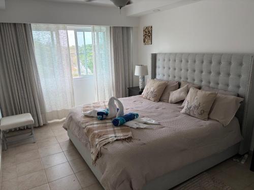 ein Schlafzimmer mit einem großen Bett mit großem Kopfteil in der Unterkunft Oasis by the beach Retiro 1 in Punta Cana