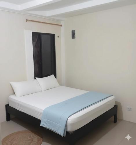 een slaapkamer met een bed in een witte kamer bij El delfín in Santa Elena