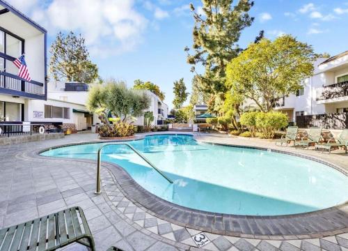 a swimming pool with a bench next to a building at A Tranquil Retreat in Tarzana CA in Tarzana