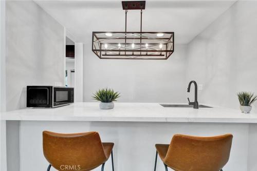 a kitchen with a counter with two chairs and a microwave at A Tranquil Retreat in Tarzana CA in Tarzana