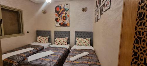 een rij bedden in een kamer met bij Apprt Ennakhil 3 in El Jadida