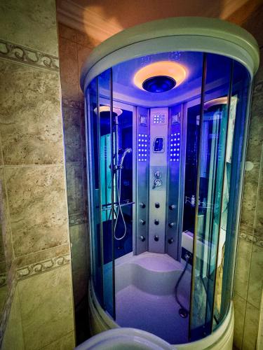 a bathroom with a shower with a glass door at Ember Residence Spacious 2BR Apartment near Eternal Flame in Sarajevo