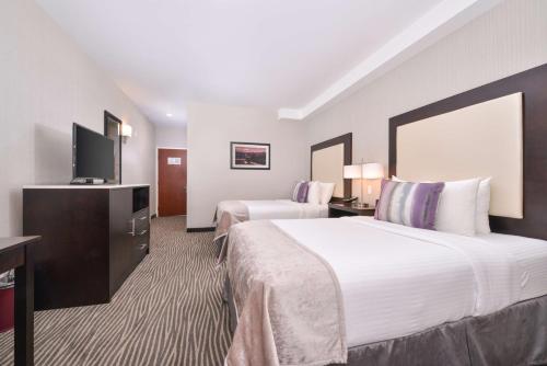 a hotel room with two beds and a flat screen tv at Best Western Plus Hotel at the Convention Center in Long Beach
