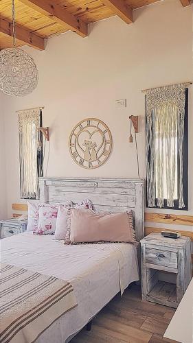 a bedroom with a large bed with a clock on the wall at Brisas De Las Sierras in Villa Ciudad Parque