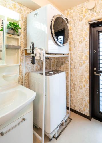 a bathroom with a hair dryer on the wall at ゲストハウス海と石 in Takamatsu