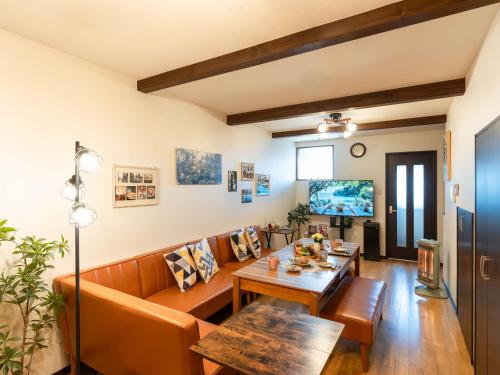 een woonkamer met een bank en een tafel bij ゲストハウス海と石 in Takamatsu