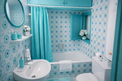 a blue bathroom with a sink and a tub at Can Pau Llanca Sf Parascheva in Llança