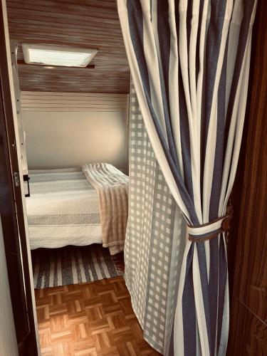 une petite pièce avec un rideau à côté d'un lit dans l'établissement Cabaña casa rodante, à Tongoy