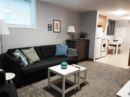 a living room with a black couch and a table at Apartment In Saskatoon in Saskatoon