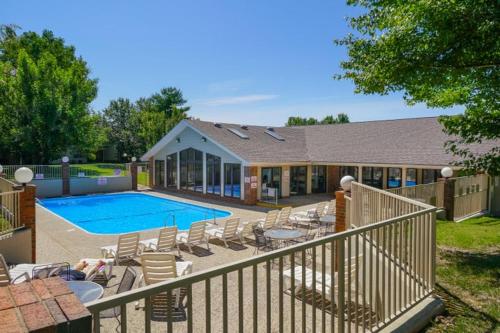 a house with a swimming pool and chairs next to at Comfortable updated Condo with No steps in Branson