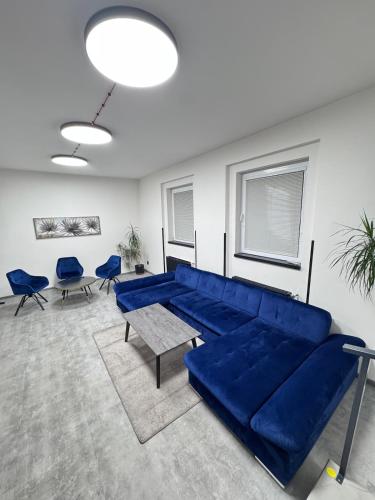 een woonkamer met een blauwe bank en blauwe stoelen bij Teplice accommodation in Teplice