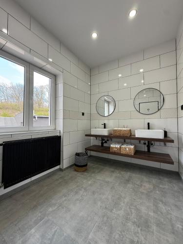 a bathroom with two sinks and a large window at Teplice Apartments in Teplice