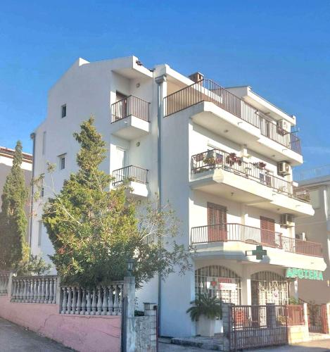 een wit gebouw met balkons aan de zijkant bij Apartment Maruni in Šušanj