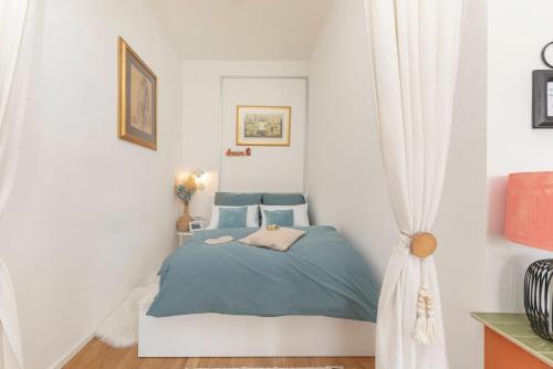 a small bedroom with a blue bed and curtains at Casa 1895 , Boutique Stay in a Historic Townhouse near the Beer Fountain in Žalec