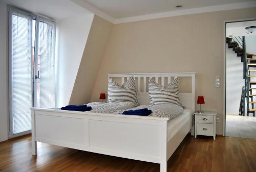 een wit bed in een kamer met een spiegel bij Trafford Sky Homes in Leipzig