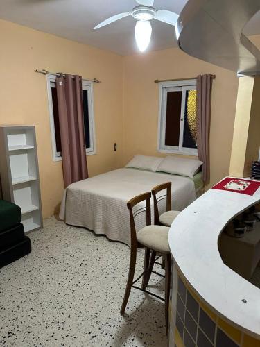 une petite chambre avec deux lits et une cuisine dans l'établissement Residencial Brila Mar, à Capão da Canoa