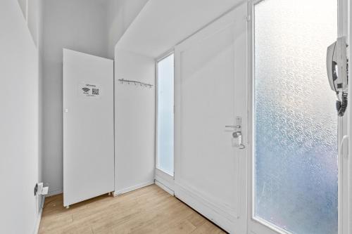 une salle de bain avec des murs blancs et une porte vitrée dans l'établissement Apartment Uthman Berlin-Neukölln, à Berlin
