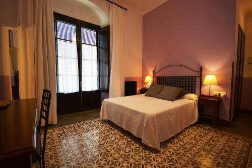 a bedroom with a bed and a large window at Hotel Casa de los Azulejos in Córdoba