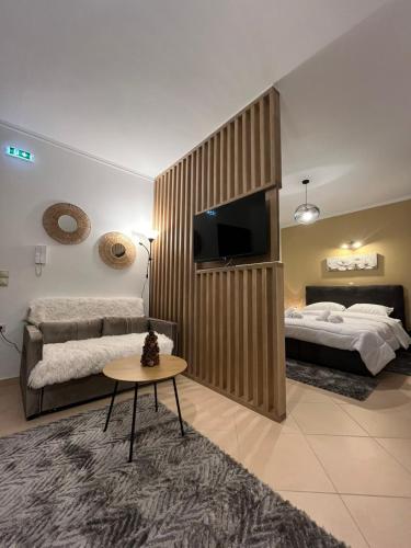 a bedroom with two beds and a tv and a table at Onar Apartments in Kalavrita