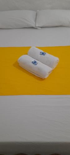 twee handdoeken liggen bovenop een bed bij Casa Hostel Necoclí Playa Brisa y Mar in Necoclí