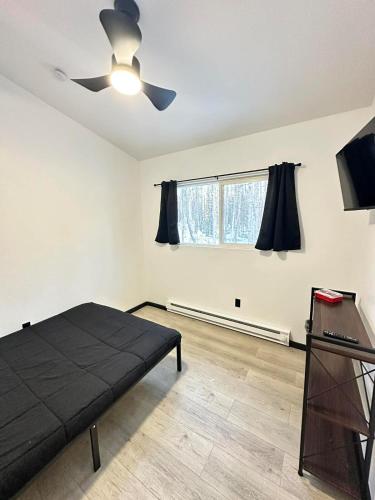 une chambre avec un lit et un ventilateur de plafond dans l'établissement Bears Den Cabin #3, à Houston