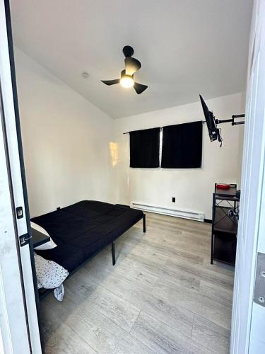 une chambre avec un lit et un ventilateur de plafond dans l'établissement Bears Den Cabin #3, à Houston