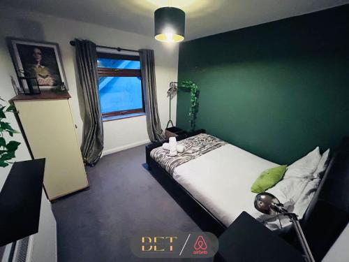 - une chambre dotée d'un lit avec un mur vert dans l'établissement Carden Hill House - 4 Bedrooms - Sleeps 9 - Free Parking - Games Room - Ideal for Contractors, Families and Large Groups, à Brighton et Hove