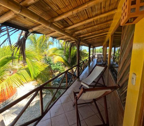 un balcone di una casa con sedie e palme di Habitaciones en Vichayito a Vichayito