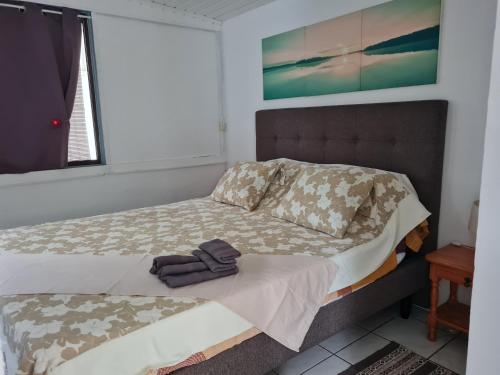 ein Schlafzimmer mit einem Bett, auf dem zwei Handtücher liegen in der Unterkunft mahinas lodge in Mahina