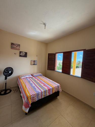 een slaapkamer met een bed en twee ramen bij Casa da Duna Moitas-Icaraizinho de Amontada Ceará in Praia de Moitas