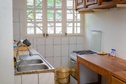 een keuken met een spoelbak en een fornuis bij Villa Bernadette aéroport in Pointe-Noire