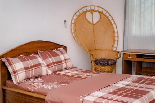 een slaapkamer met een bed en een stoel bij Villa Bernadette aéroport in Pointe-Noire