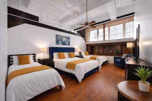 a hotel room with two beds and a table at St. Vincent Lofts in Los Angeles