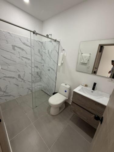 een badkamer met een douche, een toilet en een wastafel bij Tierra Bendecida Hotel Boutique in Villavicencio