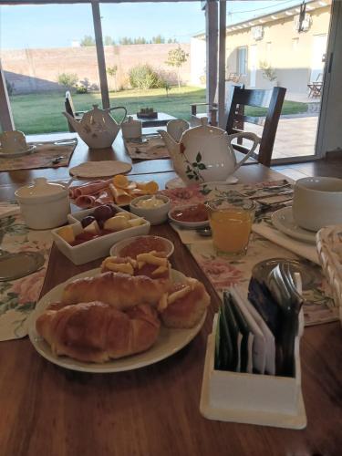 een houten tafel met borden met eten erop bij Posada Rojo Malbec in San Rafael