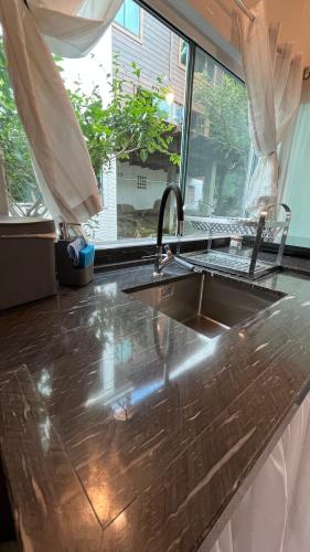 a kitchen counter with a sink and a window at Tiny House Armação no Morro in Florianópolis